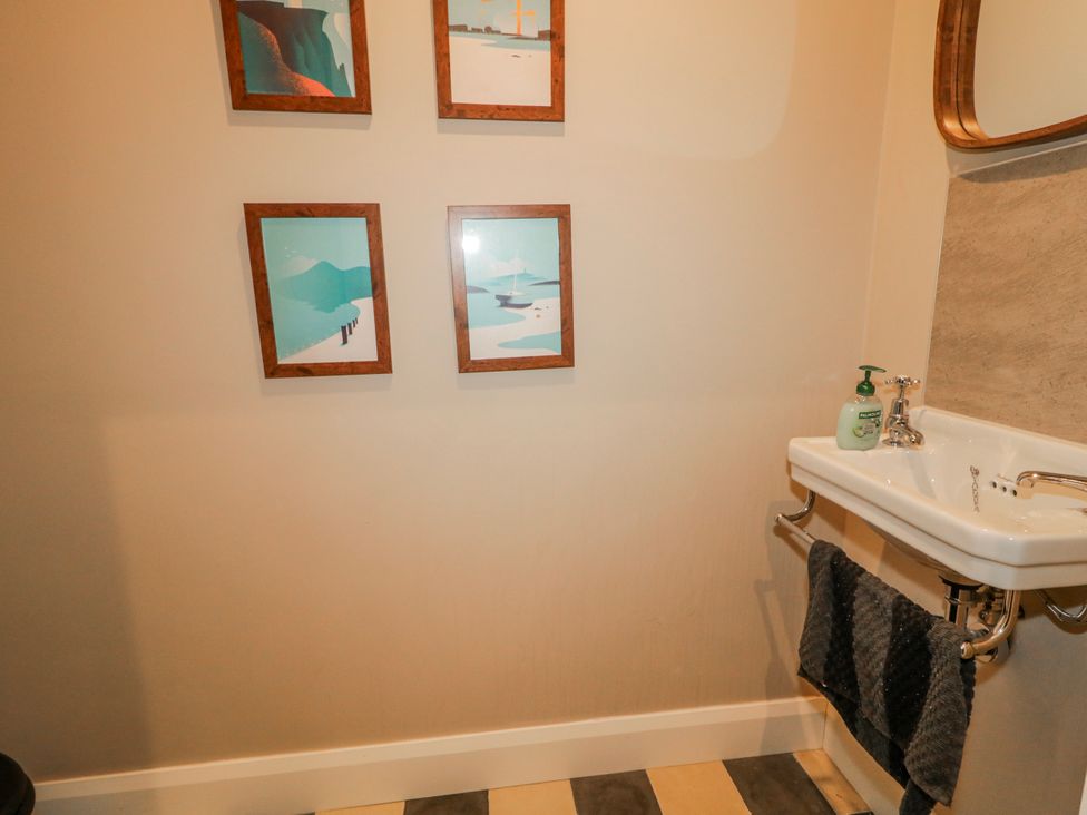 A bathroom with a sink and wall art at Cloneytrace Mines in Broughshane