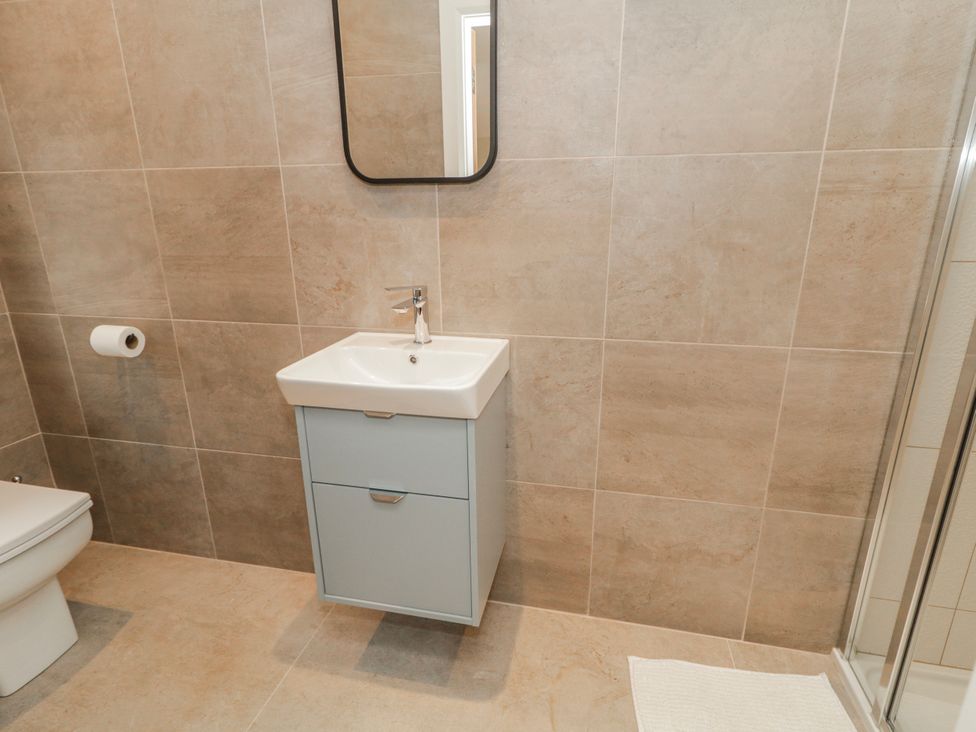 A bathroom with a sink cabinet and a toilet at Cloneytrace Mines Broughshane
