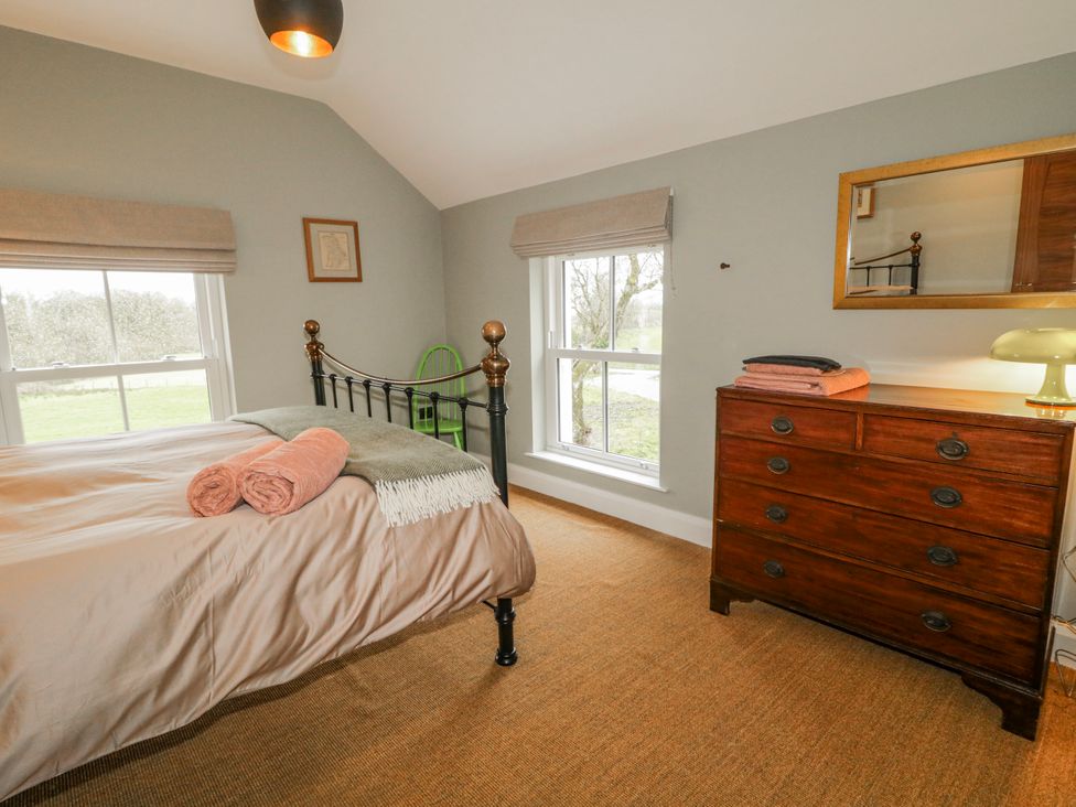 A bedroom with a bed and a dresser at Cloneytrace Mines Broughshane