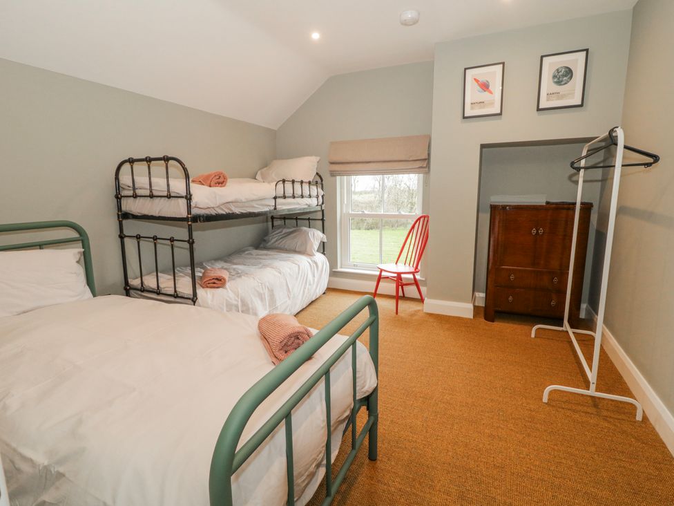 A bedroom with a bunk bed and a single bed at Cloneytrace Mines in Broughshane