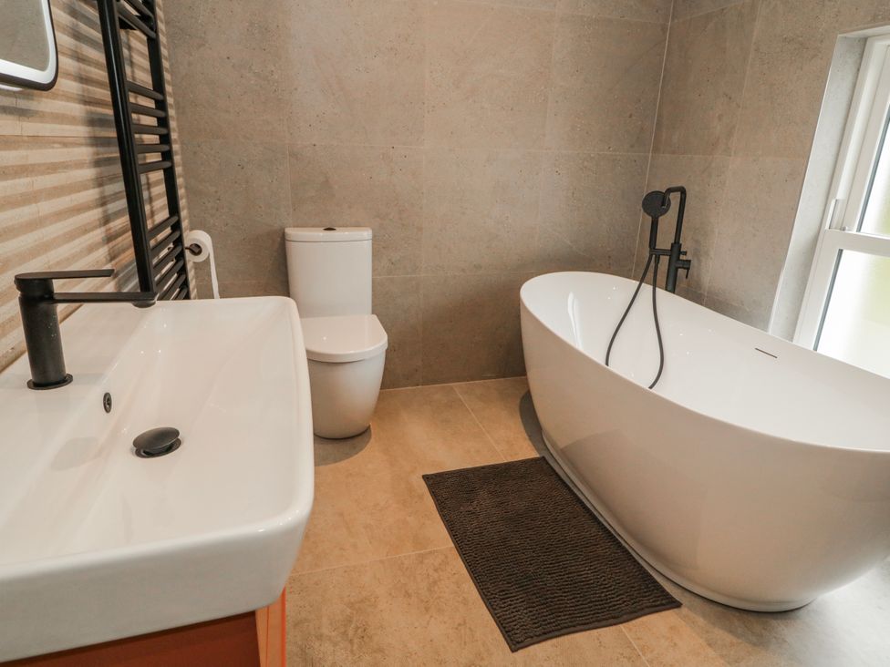 A bathroom with a bathtub, toilet, and sink at Cloneytrace Mines in Broughshane