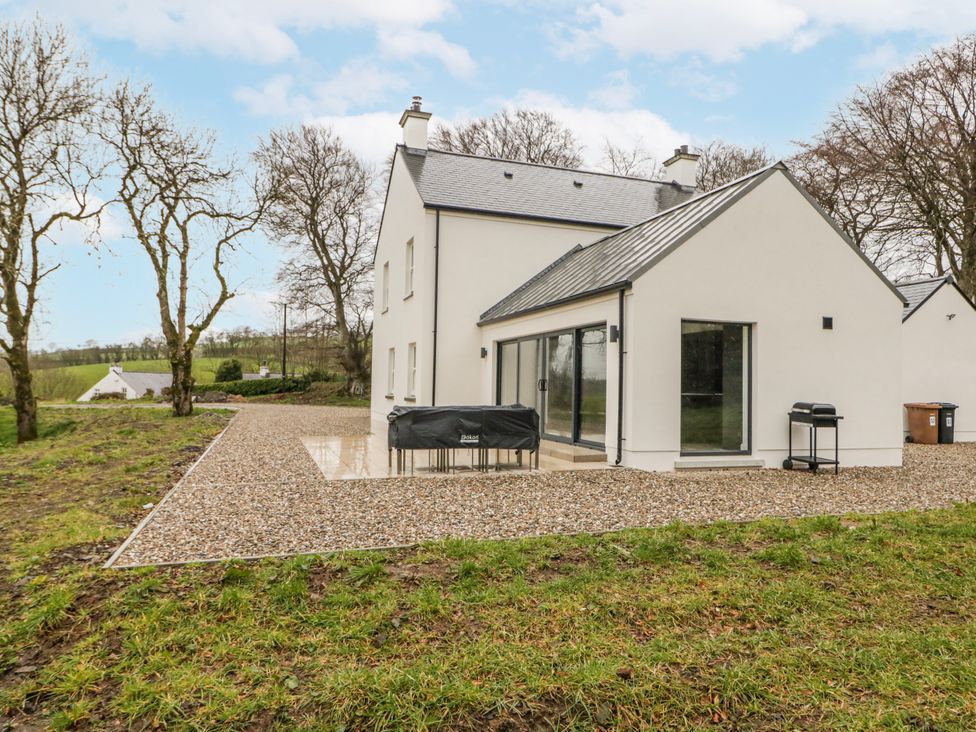 A house with a gravel driveway and barbecue grill at Cloneytrace Mines in Broughshane