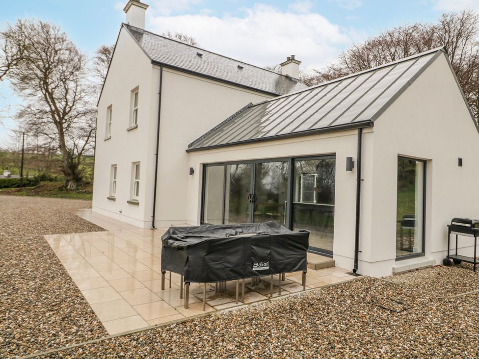 An outdoor area with a house and a covered table at Cloneytrace Mines Broughshane