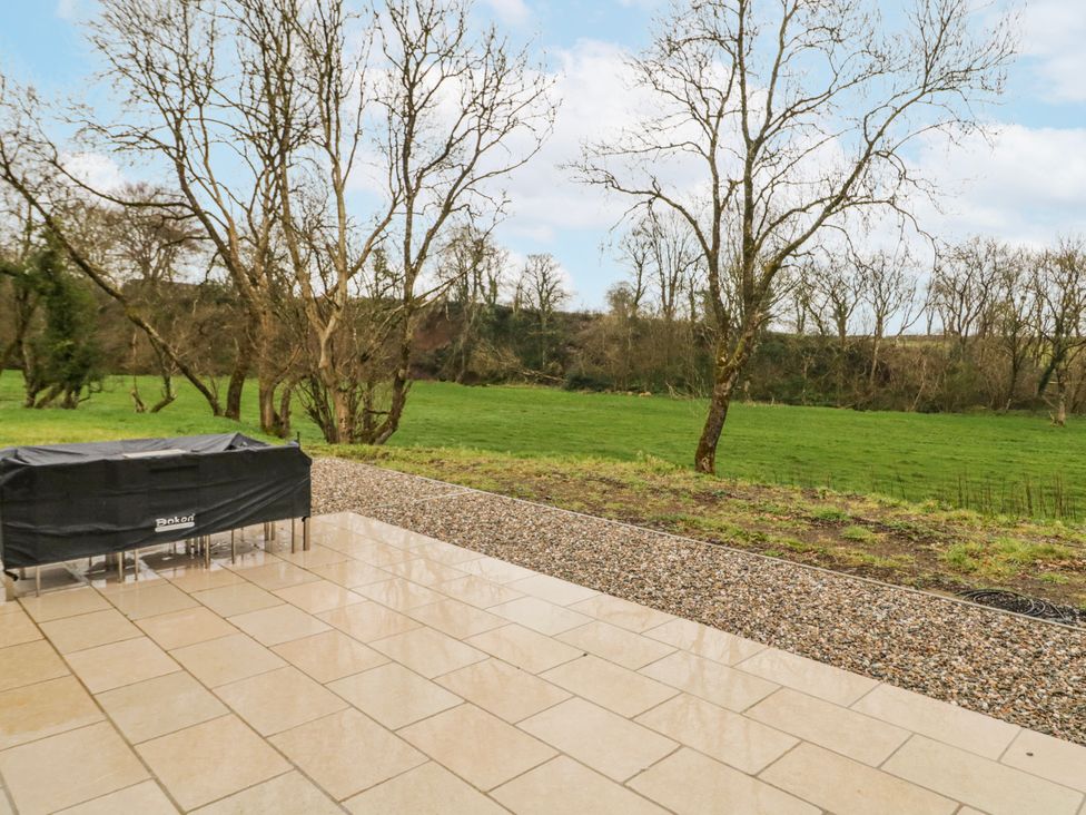 An outdoor area with a table cover and trees at Cloneytrace Mines in Broughshane