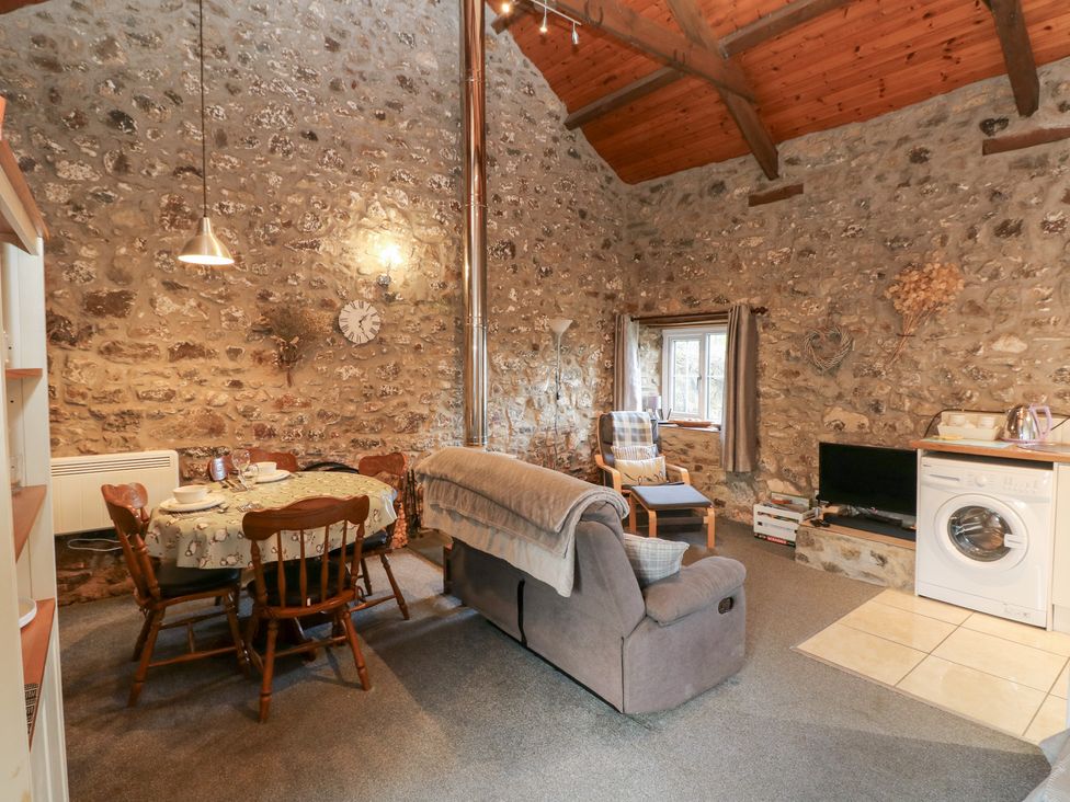 A living room with a dining table and chairs at 8 Rogeston Cottages Haverfordwest
