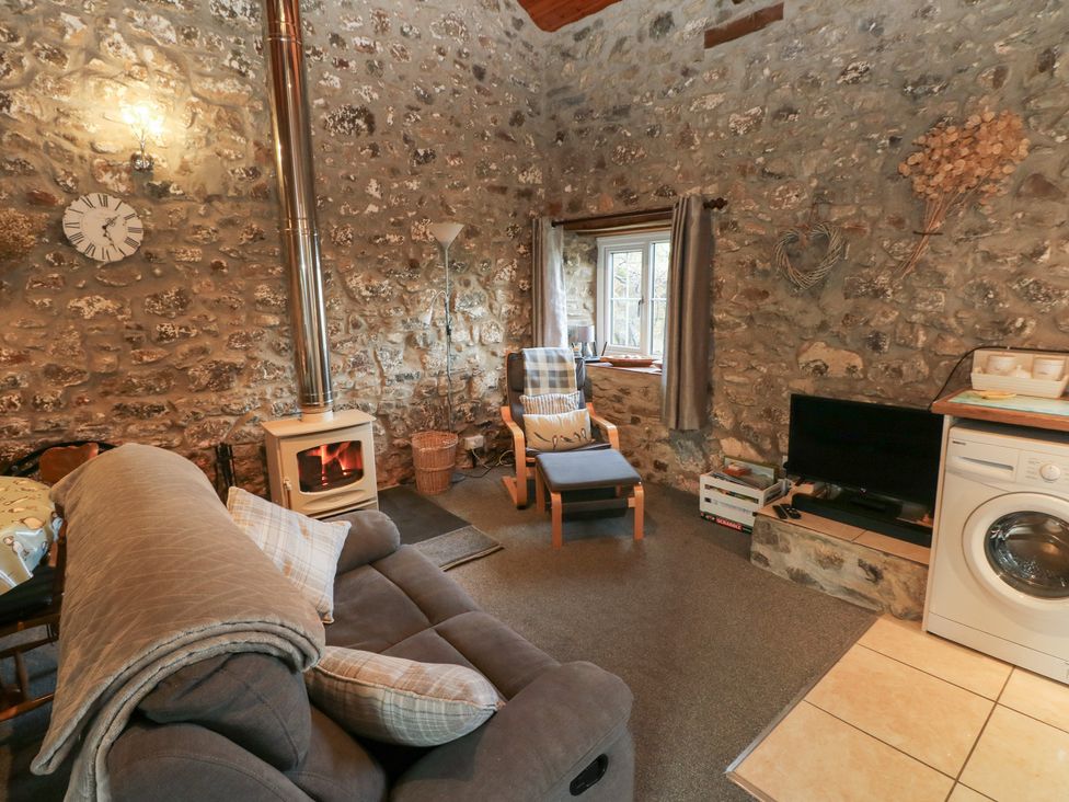 A living room with a sofa and television at 8 Rogeston Cottages Haverfordwest