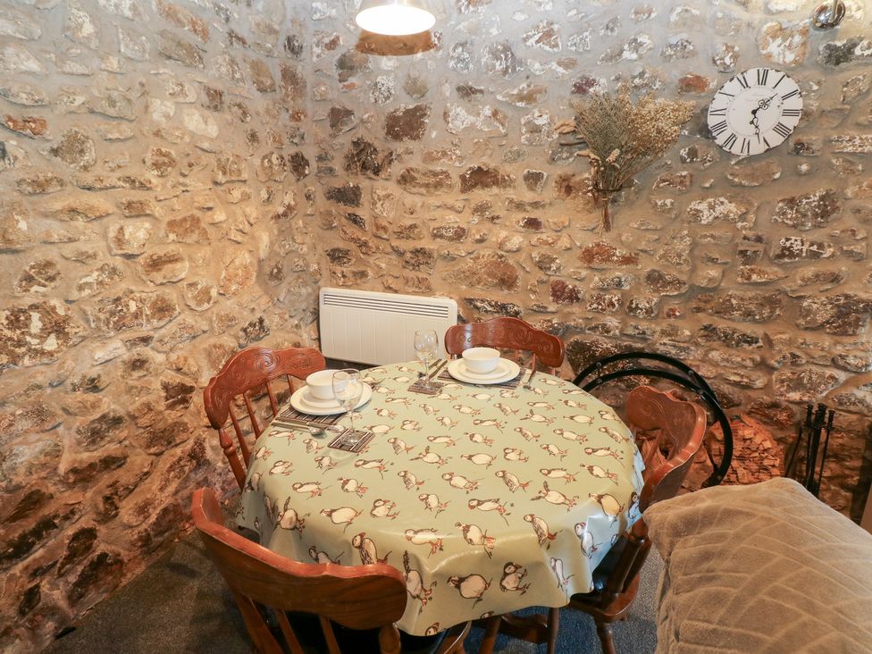 A dining table set with tableware and chairs at 8 Rogeston Cottages in Haverfordwest