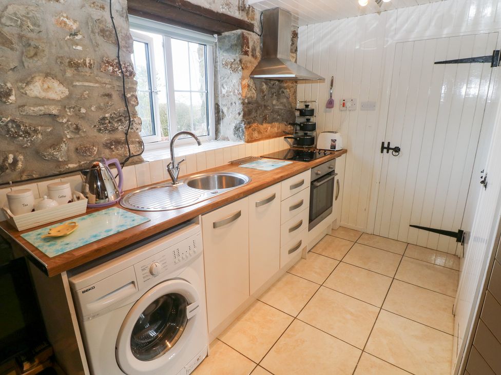 A kitchen with a washing machine and stove at 8 Rogeston Cottages Haverfordwest