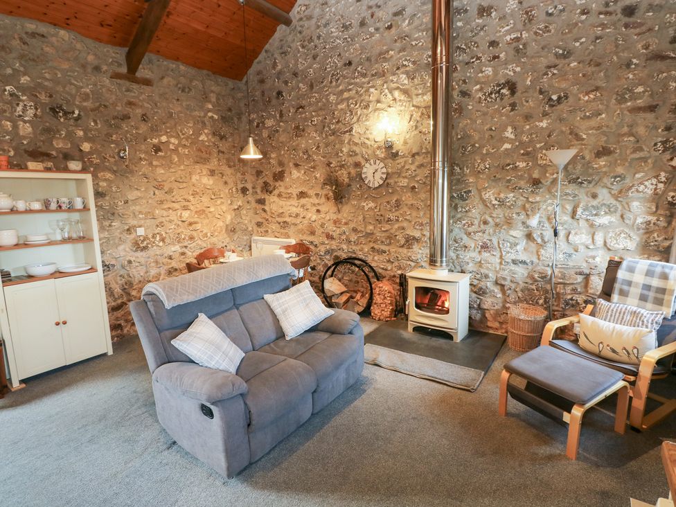 A living room with a sofa and fireplace at 8 Rogeston Cottages in Haverfordwest
