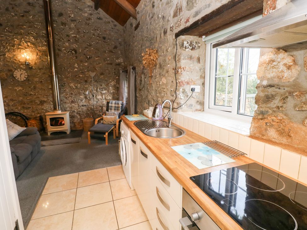 A kitchen with a sink and stove at 8 Rogeston Cottages Haverfordwest