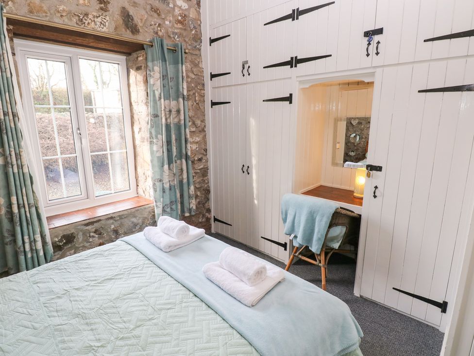 A bedroom with a bed and window at 8 Rogeston Cottages Haverfordwest