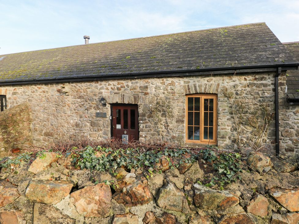 An exterior view of a stone cottage with a door and window at 8 Rogeston Cottages Haverfordwest