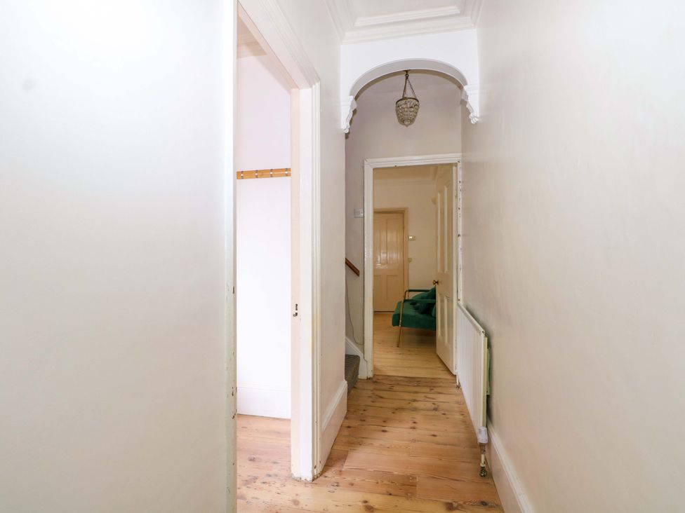 A hallway with a staircase and a light fixture at 70 High Street, Canterbury