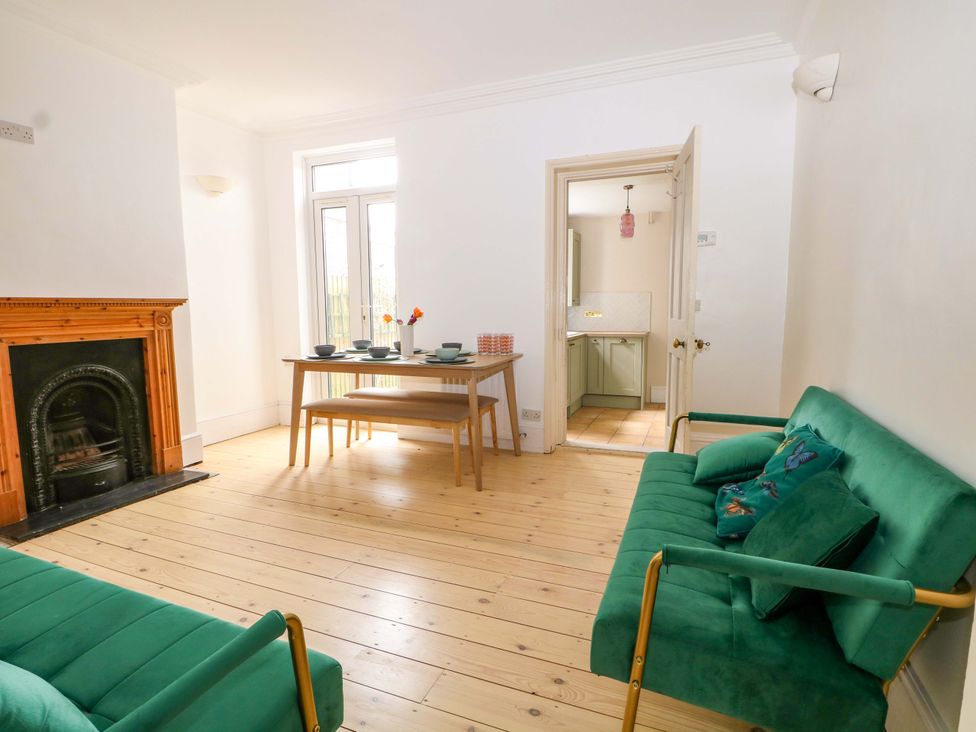 A living room with a fireplace and dining table at 70 High Street in Canterbury