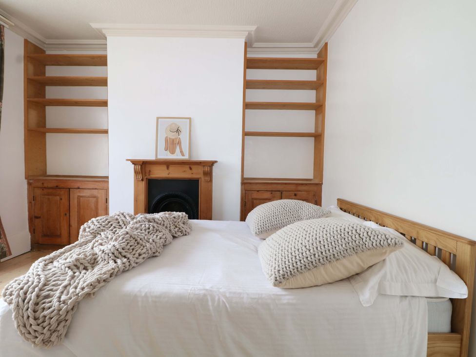 A bedroom with a bed and shelves at 70 High Street, Canterbury