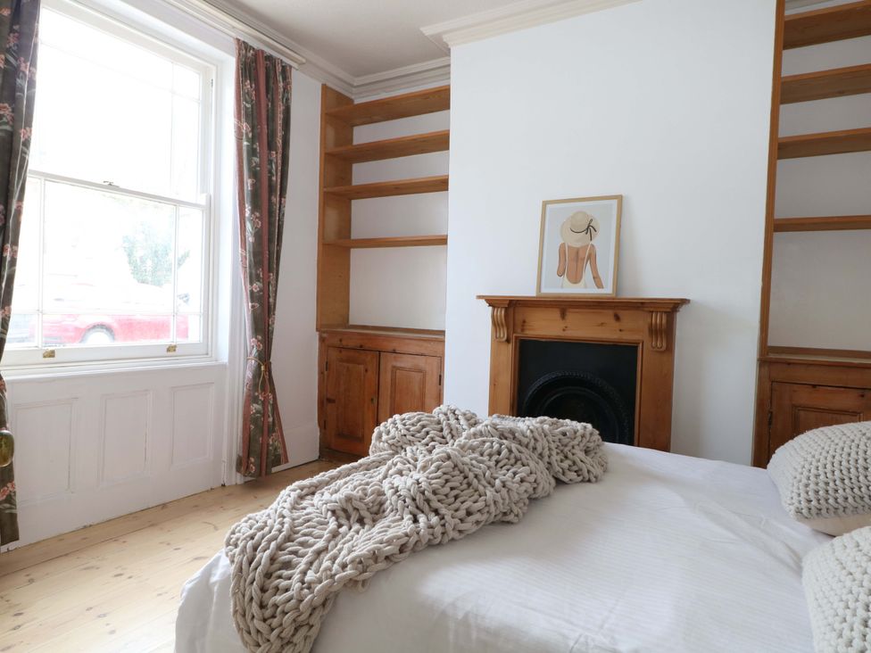 A bedroom with a bed, bookshelf and window at 70 High Street in Canterbury