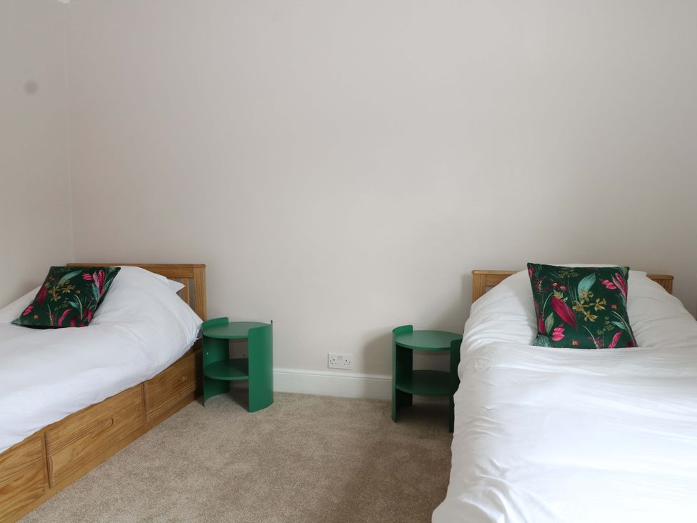 A bedroom with two beds and bedside tables at 70 High Street, Canterbury