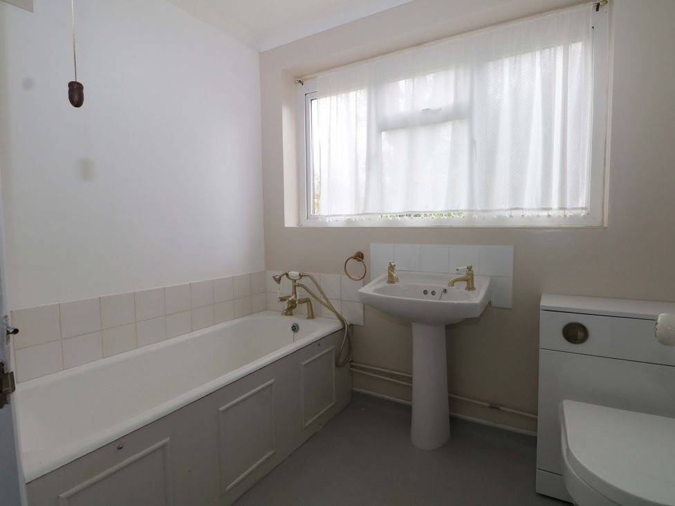 A bathroom with a bathtub, sink, and toilet at 70 High Street in Canterbury