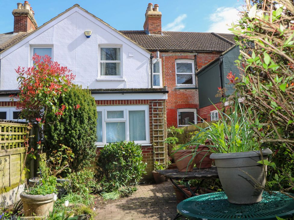 A garden with plants and seating area at 70 High Street in Canterbury