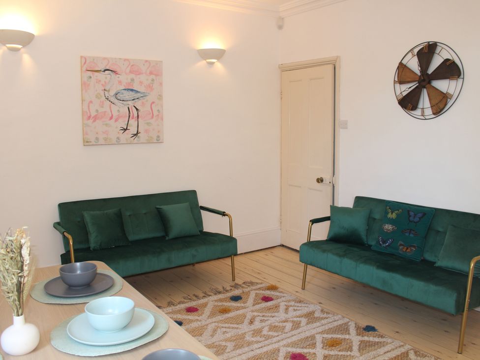 A living room with sofas and a painting at Felix Cottage in Canterbury