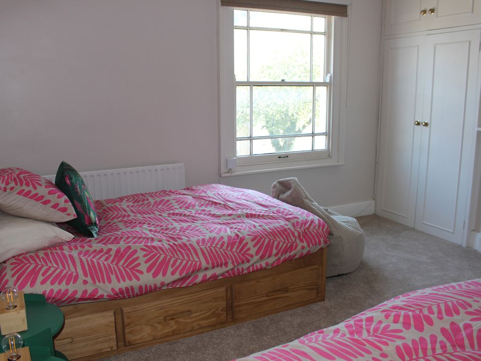 A bedroom with two beds and a window at Felix Cottage in Canterbury