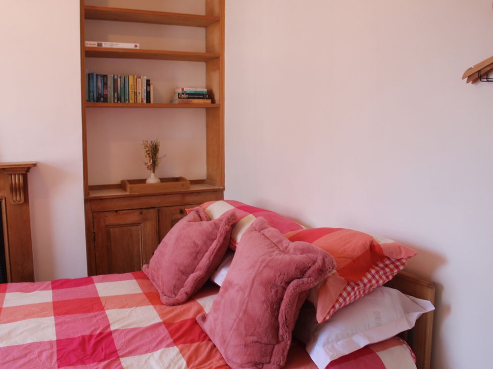 A bedroom with a bed and a bookshelf at Felix Cottage in Canterbury