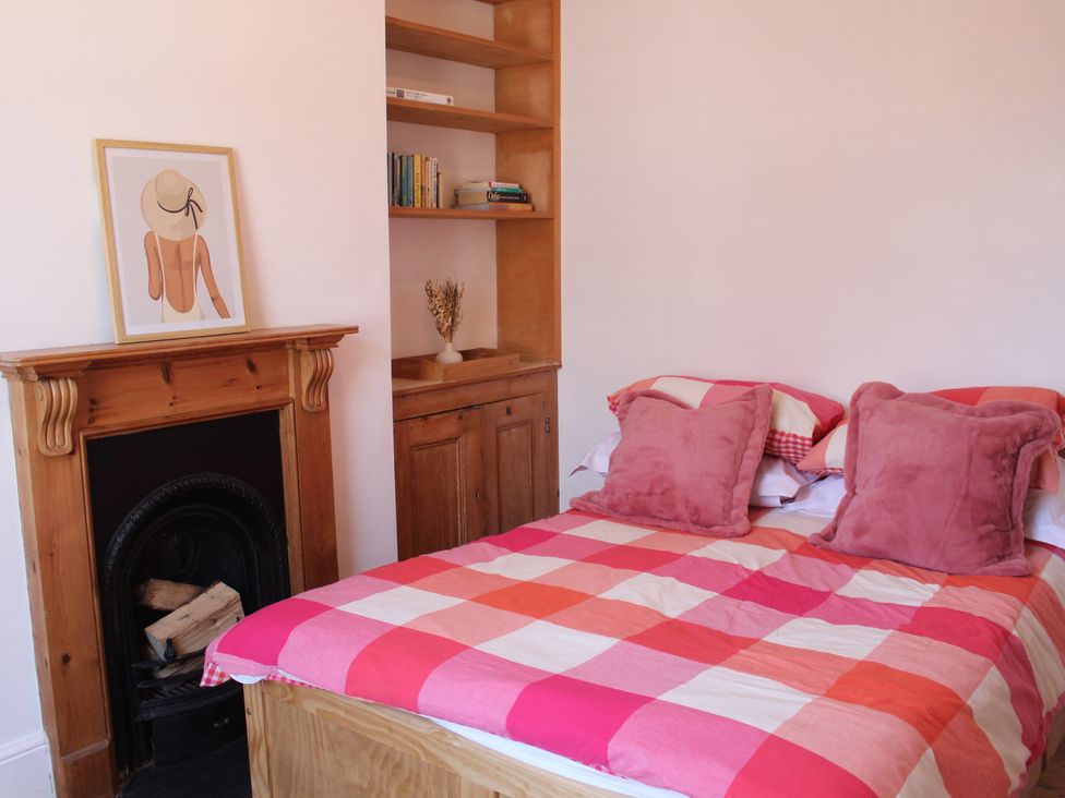 A bedroom with a bed and bookshelf at Felix Cottage in Canterbury