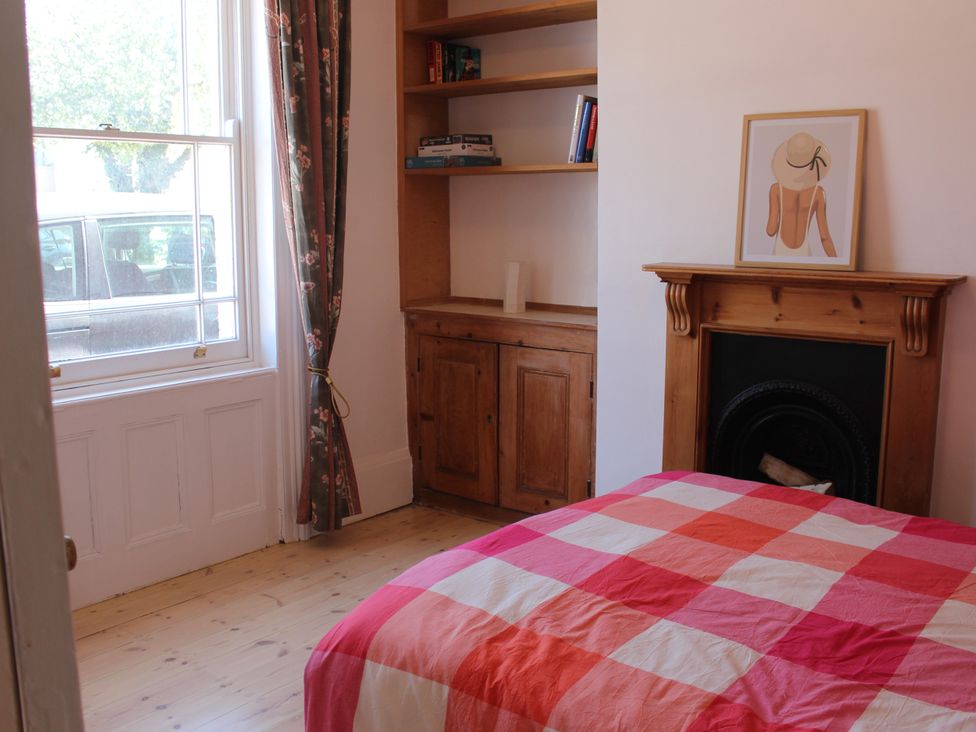 A bedroom with a bed and bookshelf at Felix Cottage Canterbury
