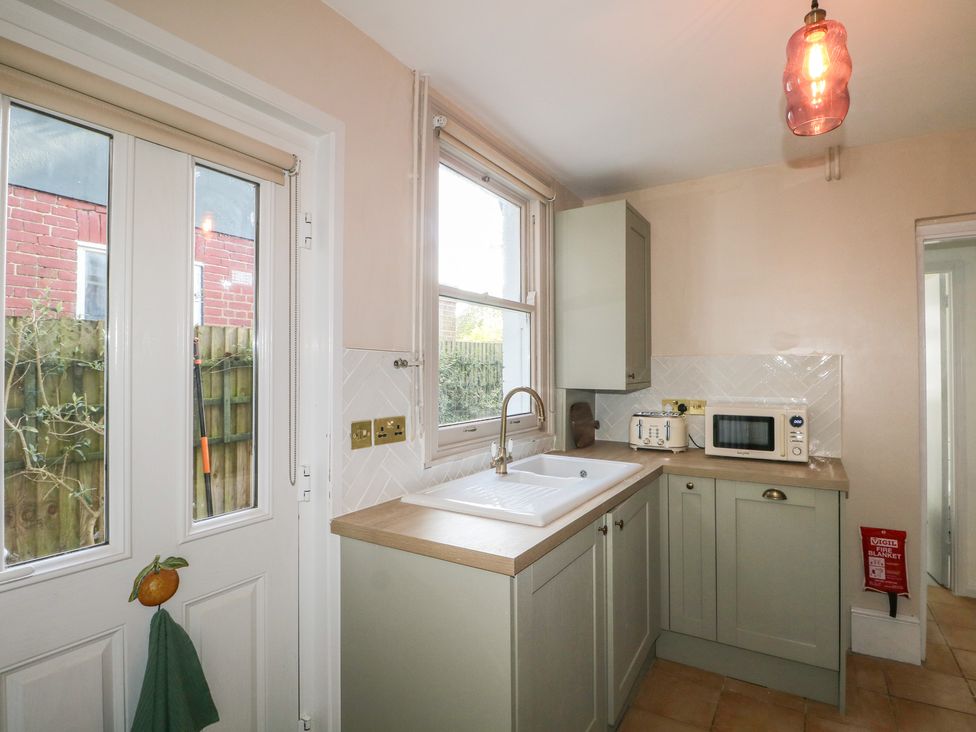 A kitchen with a sink and microwave at Felix Cottage in Canterbury