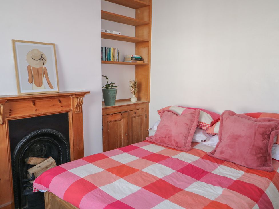 A bedroom with a bed and shelf at Felix Cottage in Canterbury