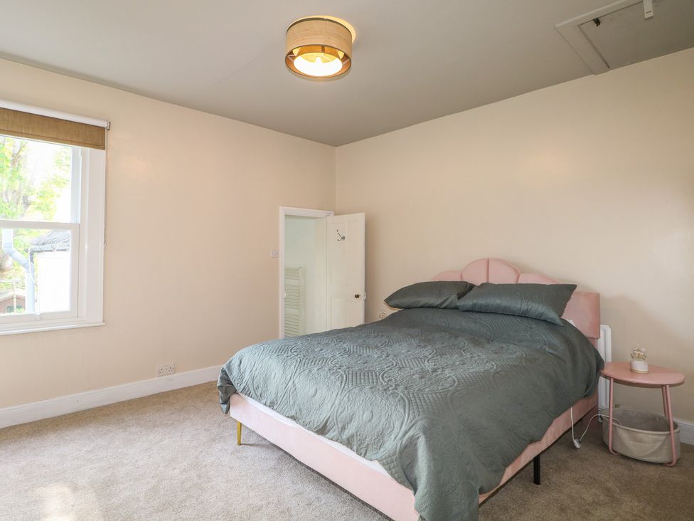 A bedroom with a bed and bedside table at Felix Cottage in Canterbury