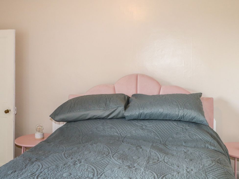 A bedroom with a bed and bedside table at Felix Cottage in Canterbury