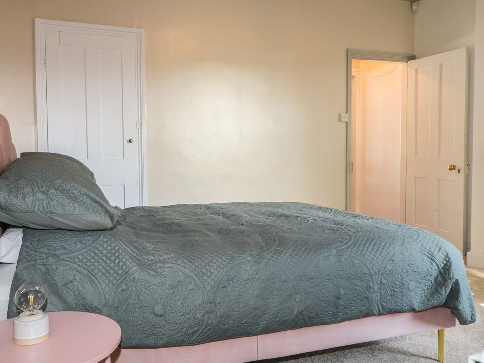 A bedroom with a bed and door at Felix Cottage in Canterbury