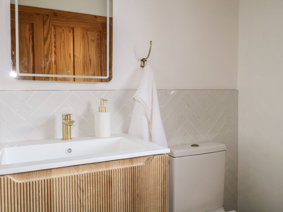 A bathroom with a sink, faucet, and towel at Felix Cottage in Canterbury