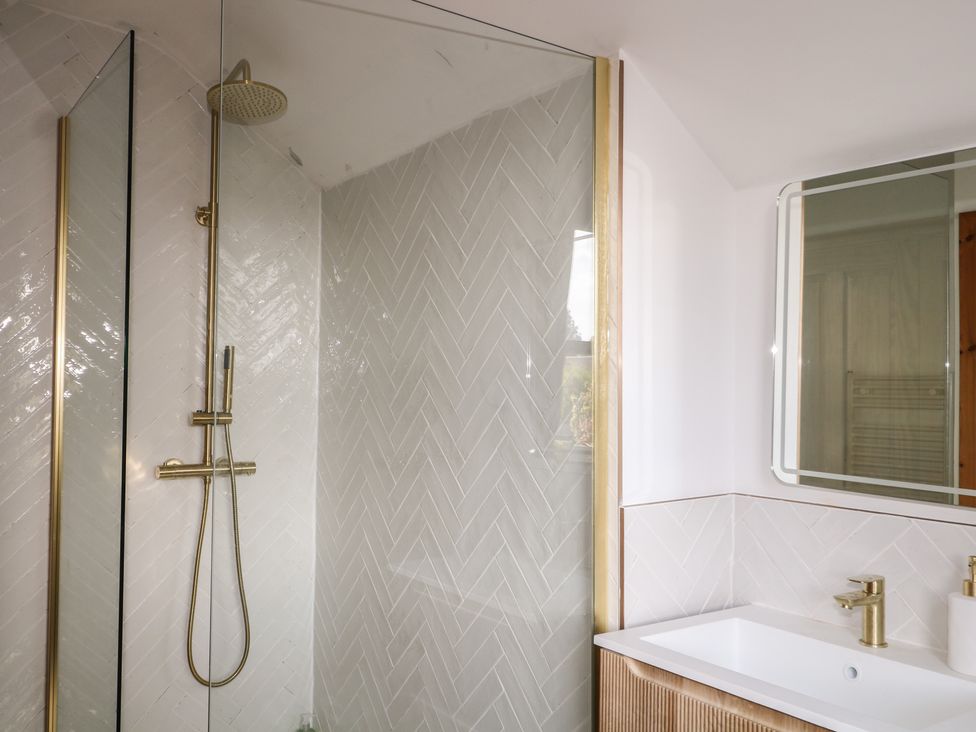 A bathroom featuring a shower with a glass partition at Felix Cottage in Canterbury