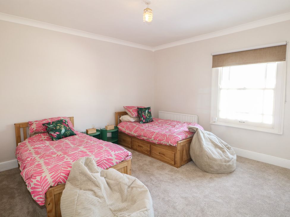 A bedroom with two beds and a bean bag at Felix Cottage in Canterbury