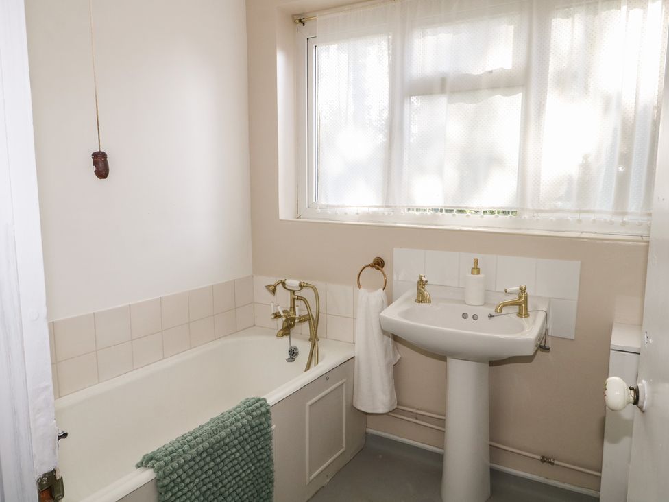 A bathroom with a bathtub and sink at Felix Cottage in Canterbury