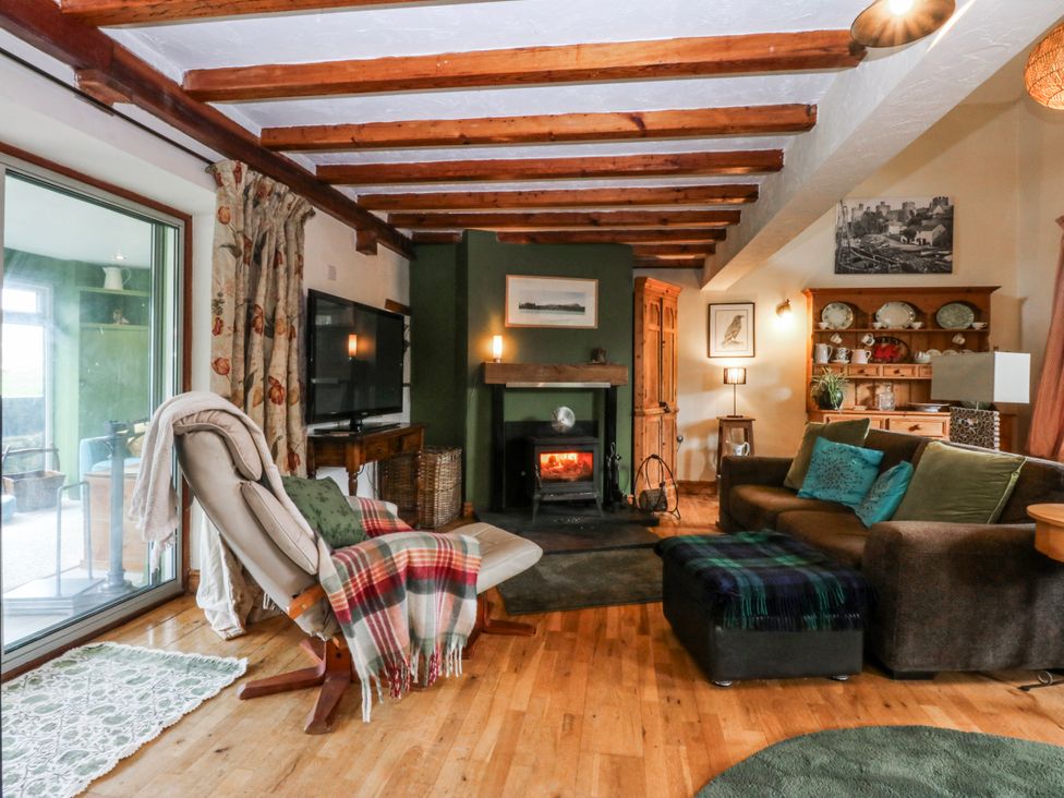 A living room with a fireplace and sofa at Pen Glorian in Conwy