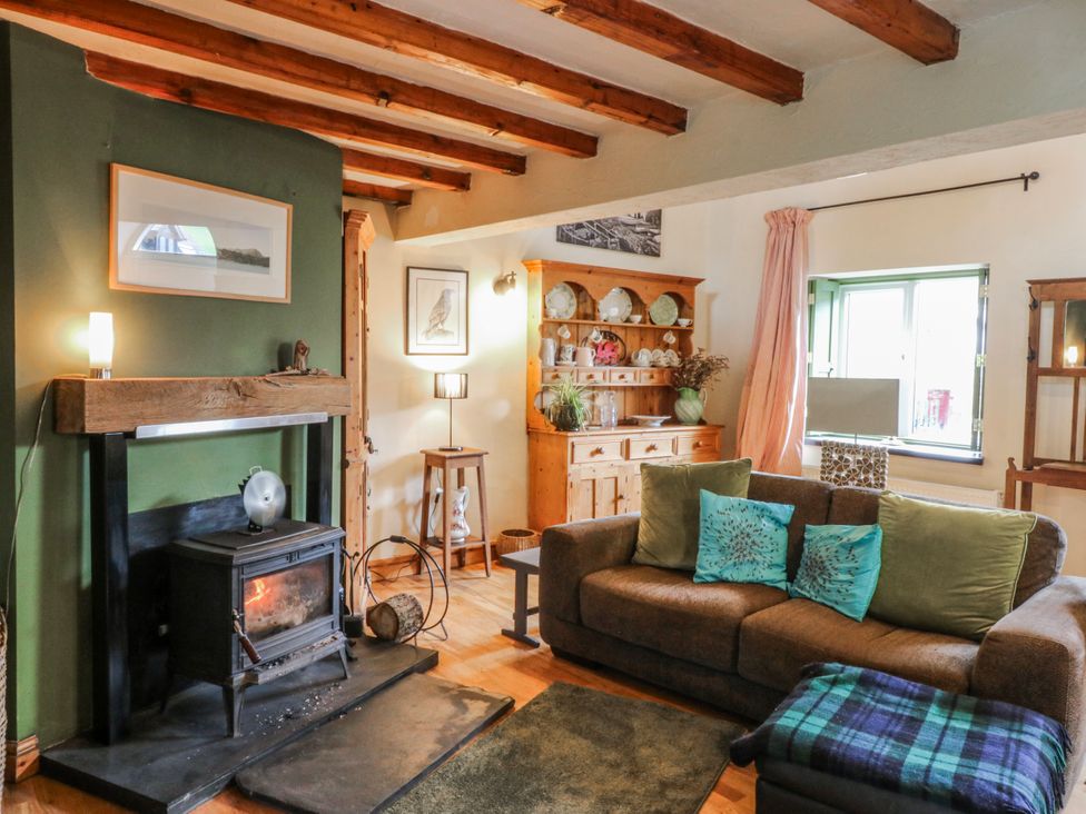 A living room with a fireplace and sofa at Pen Glorian in Conwy