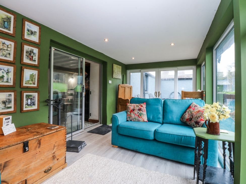 A snug with a sofa and pictures on the wall at Pen Glorian in Conwy