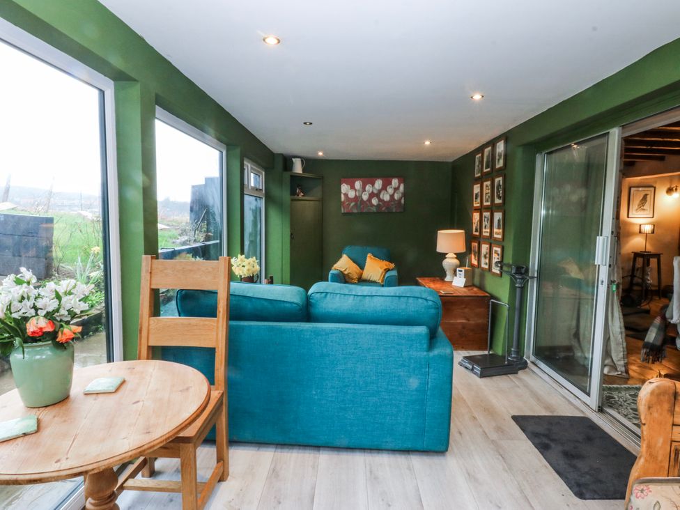 A living room with a sofa and table at Pen Glorian in Conwy