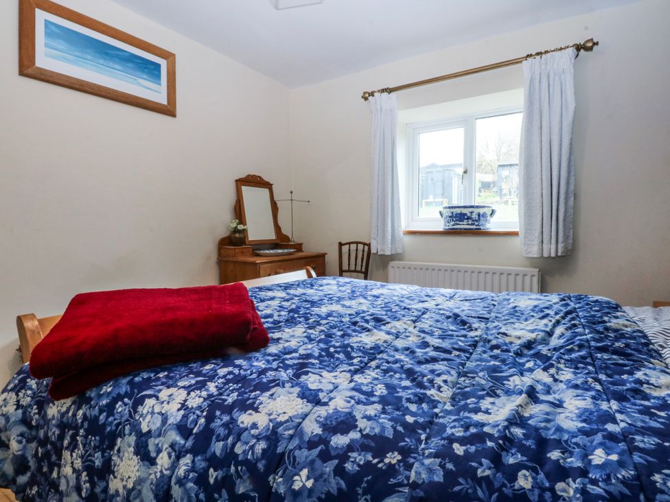 A bedroom with a bed and dresser at Pen Glorian in Conwy