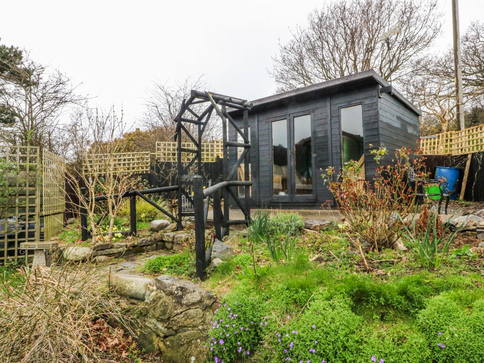 A garden with a shed and pathways at Pen Glorian in Conwy