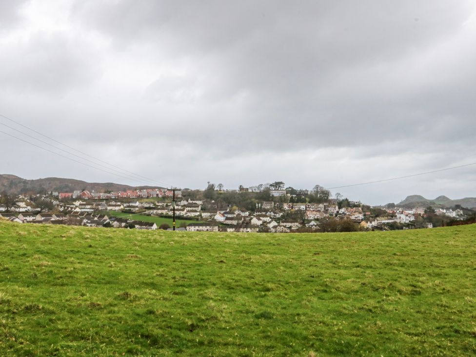 A view of houses on a hill with grass in the foreground at Pen Glorian in Conwy