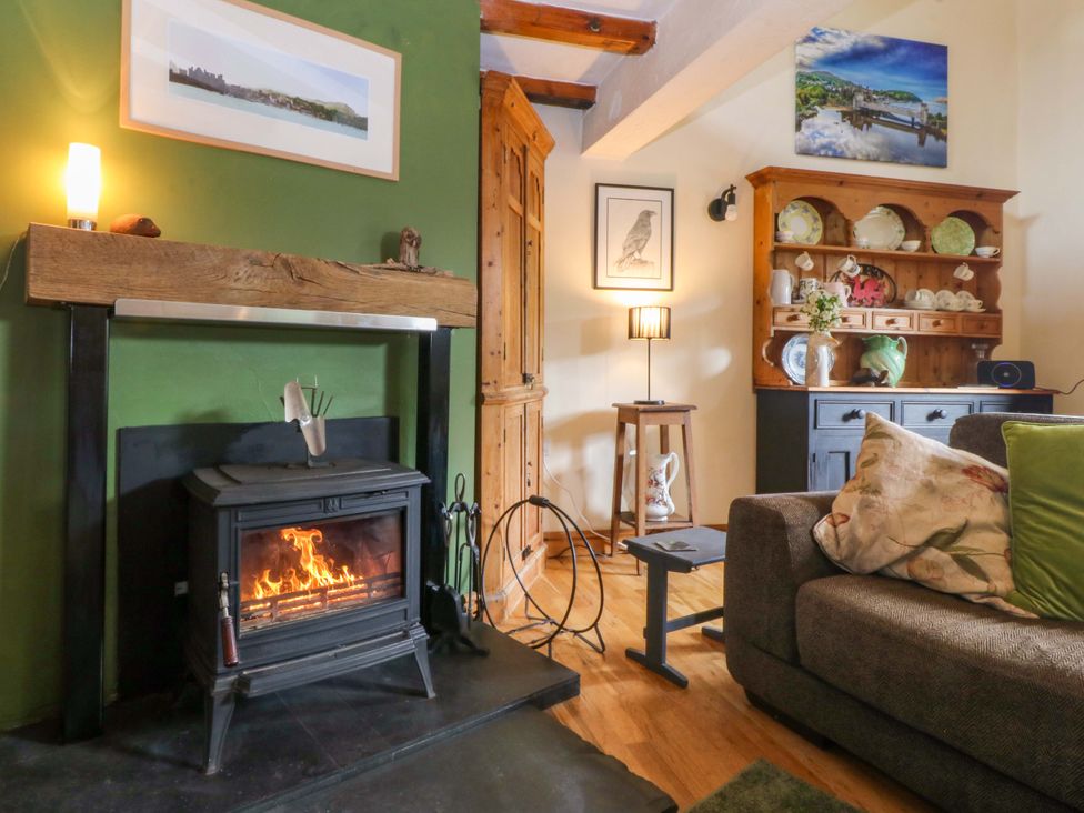 A living room with a fireplace and shelves at Pen Glorian in Conwy
