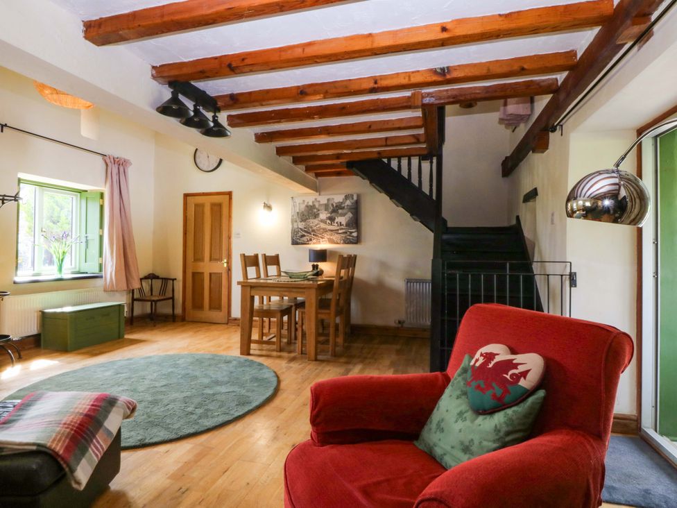 A living room with a table and chairs at Pen Glorian in Conwy