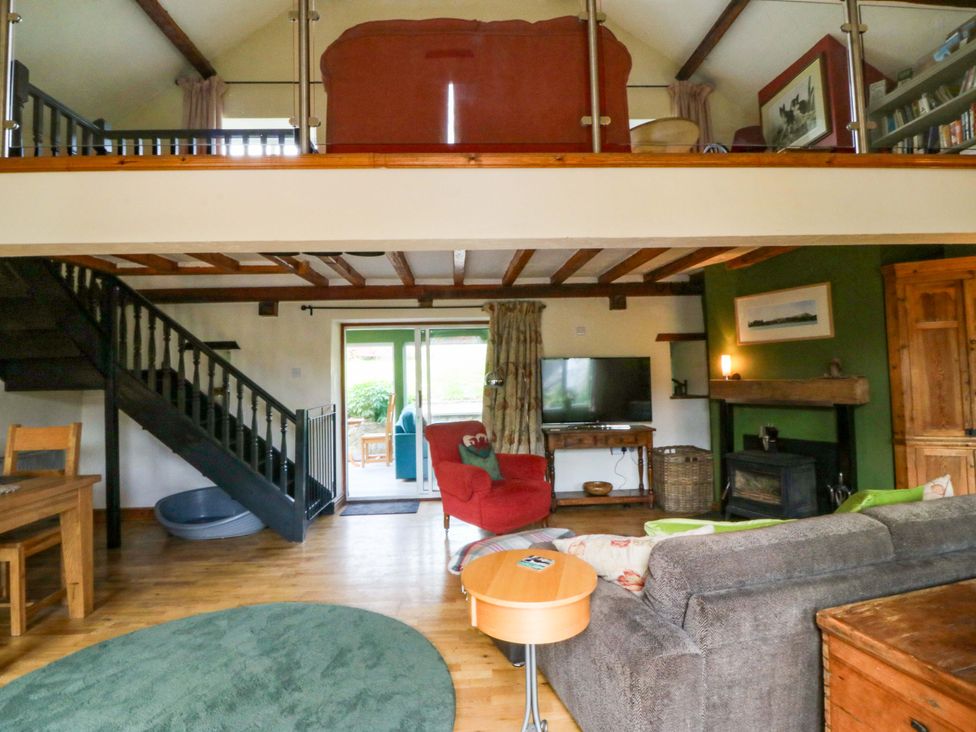 A living room with a staircase and sofa at Pen Glorian in Conwy