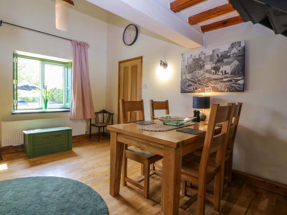 A dining room with a wooden table and chairs at Pen Glorian in Conwy