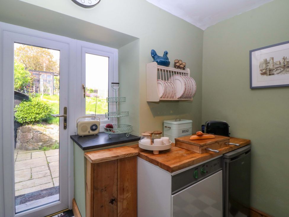 A kitchen with a door and appliances at Pen Glorian in Conwy