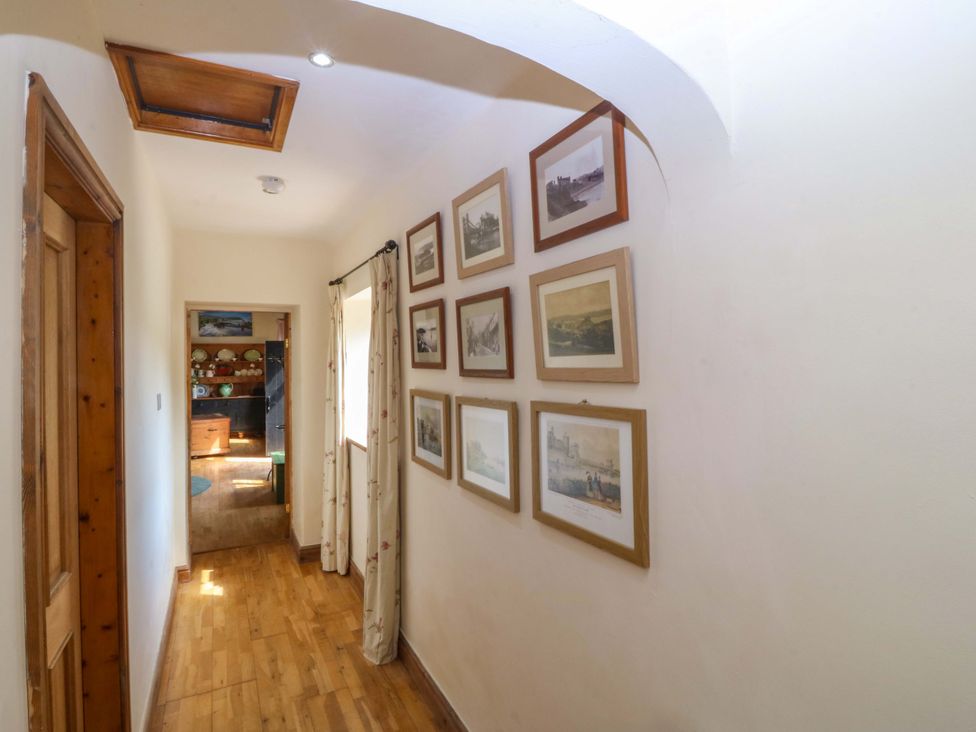 A hallway with framed pictures on the wall at Pen Glorian in Conwy